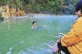 オープンした仙人風呂で一番風呂を楽しむ観光客たち（１日、和歌山県田辺市本宮町川湯で）