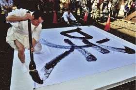 力強く「咲」という漢字を書き上げる熊野本宮大社の九鬼家隆宮司（２３日、田辺市本宮町で）