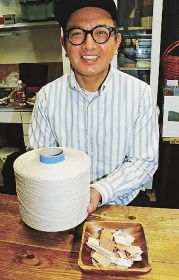 製紙用チップと紙糸のサンプルを手にする岡本一志さん（和歌山県田辺市紺屋町で）
