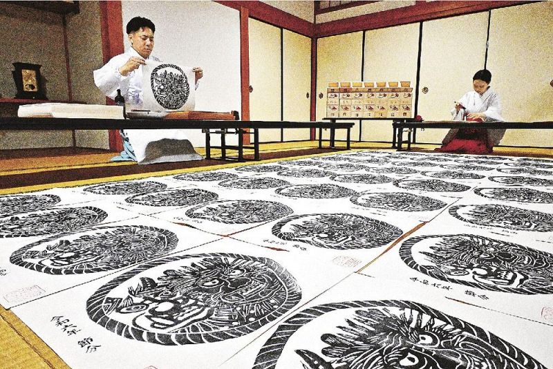 鬼面札を刷る熊野那智大社の神職（１８日、和歌山県那智勝浦町で）