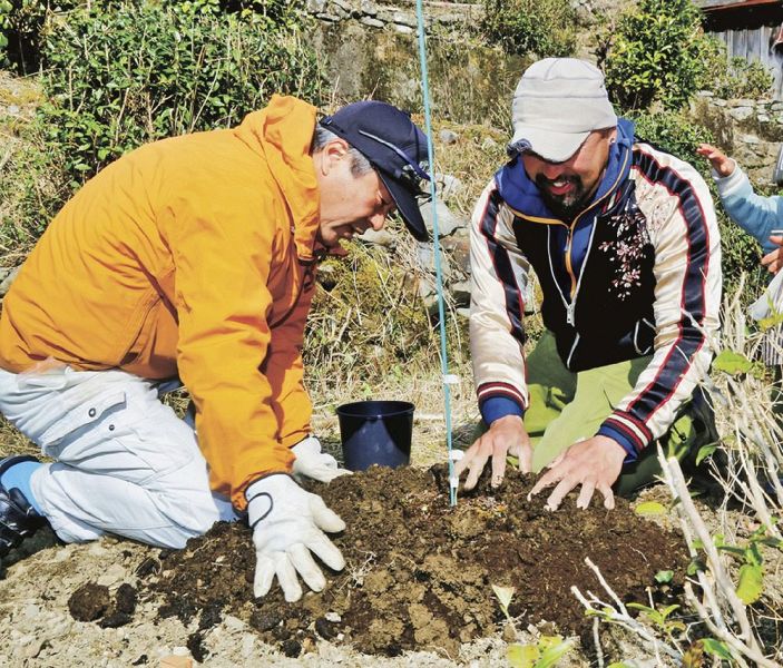 クマノザクラの苗木を植える野口貢盟さん（左）と矢倉寛之さん＝２７日、和歌山県古座川町小森川で
