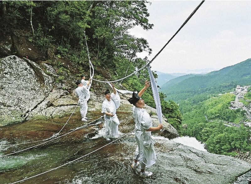 日本一の落差を誇る那智の滝の滝口で大しめ縄を張り替える神職ら（９日、和歌山県那智勝浦町で）
