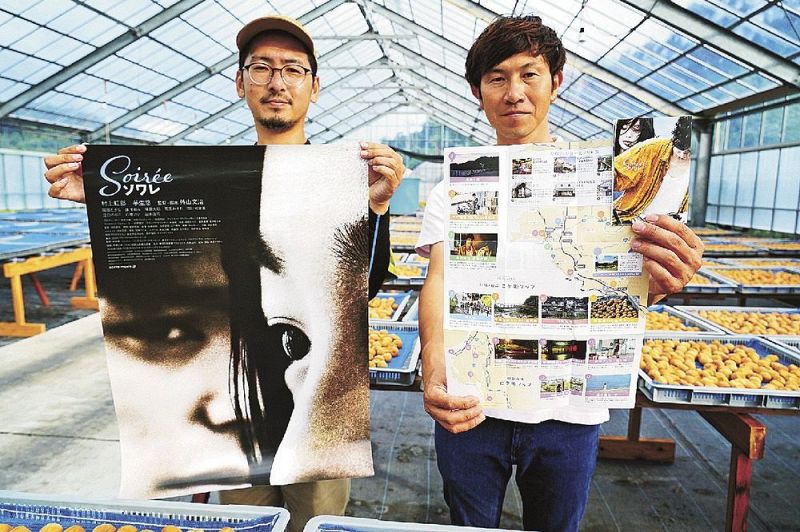 映画「ソワレ」のロケ地マップを持つ中早大輔さん（右）とポスターを持つ宮脇誠さん