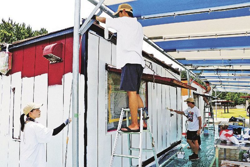 「海の家」の店舗デザインを変えようとペンキ塗りをする関西大の学生（２７日、和歌山県田辺市の田辺扇ケ浜海水浴場で）