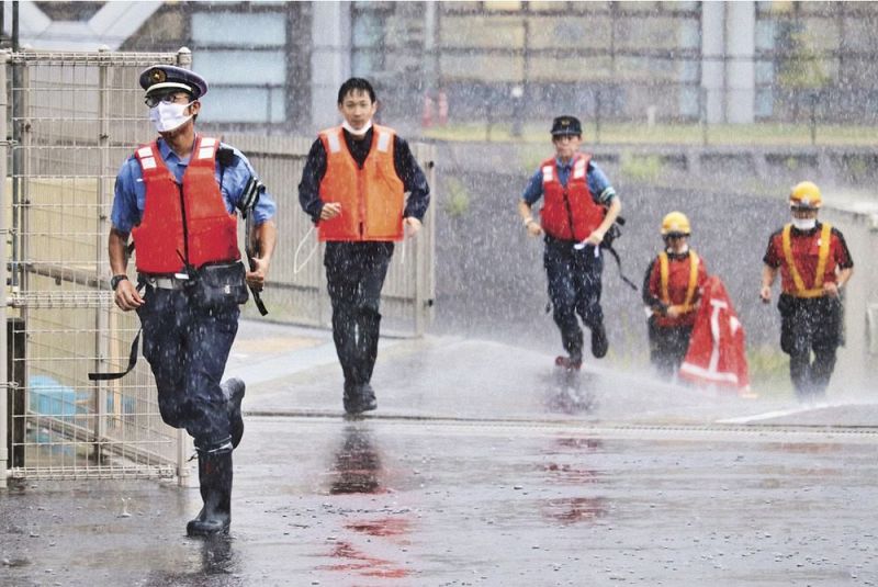 土砂降りの中、走って串本署代替指揮所へ避難する警察官ら（２日、和歌山県串本町サンゴ台で）