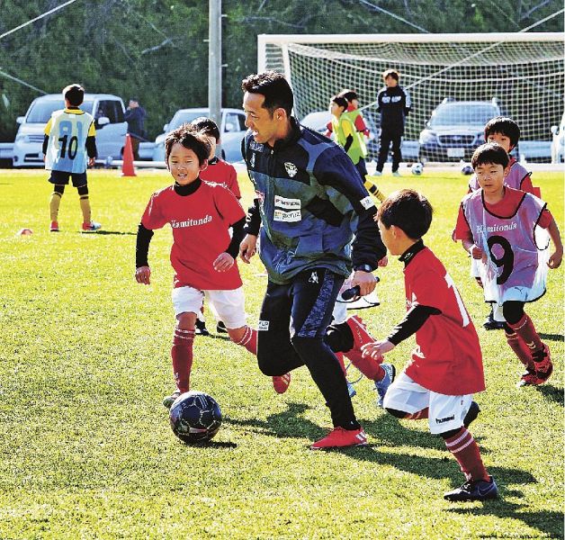 サッカー教室で横浜ＦＣのコーチと触れ合う子どもら（１８日、和歌山県上富田町朝来の上富田スポーツセンターで）