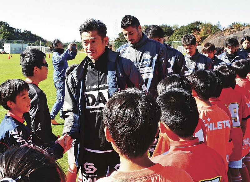 子どもたちと握手しながらグラウンドを後にする三浦知良選手