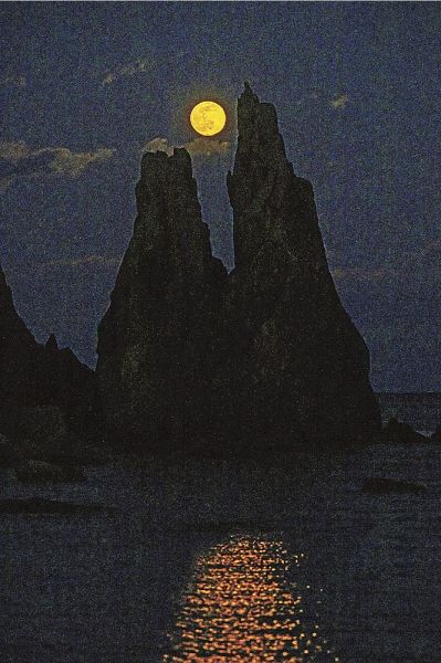 橋杭岩の奇岩と共演する月（１８日午後５時４４分、和歌山県串本町くじの川で）