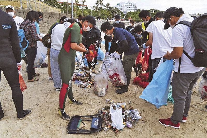 海岸や海底で拾ったごみを分別する清掃活動参加者（和歌山県白浜町の白良浜で）
