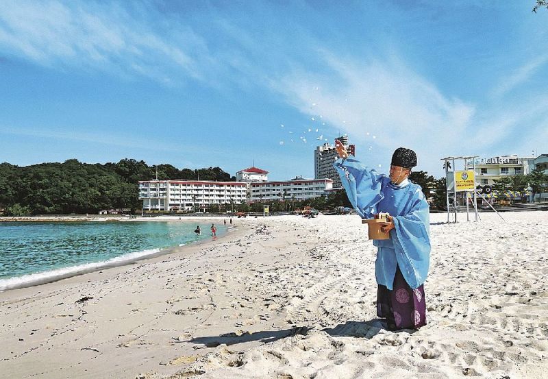 海水浴場の安全を祈る熊野三所神社の眞鍋佳輝宮司（２２日、和歌山県白浜町の白良浜で）