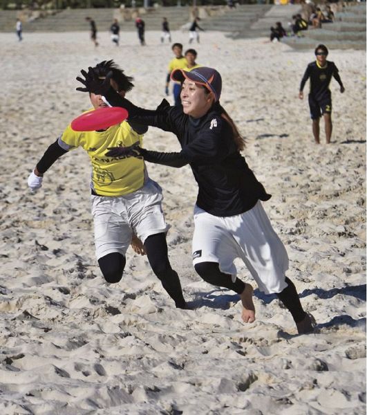 白砂のコートでディスクを追い掛ける第３回白浜ビーチアルティメット大会の参加者（２０２０年１１月１４日、和歌山県白浜町の白良浜で）