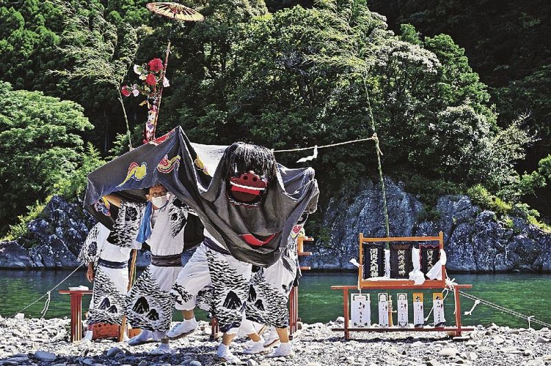 ご神体である河内島の前で獅子舞を奉納する古座青年会（和歌山県串本町古田で）