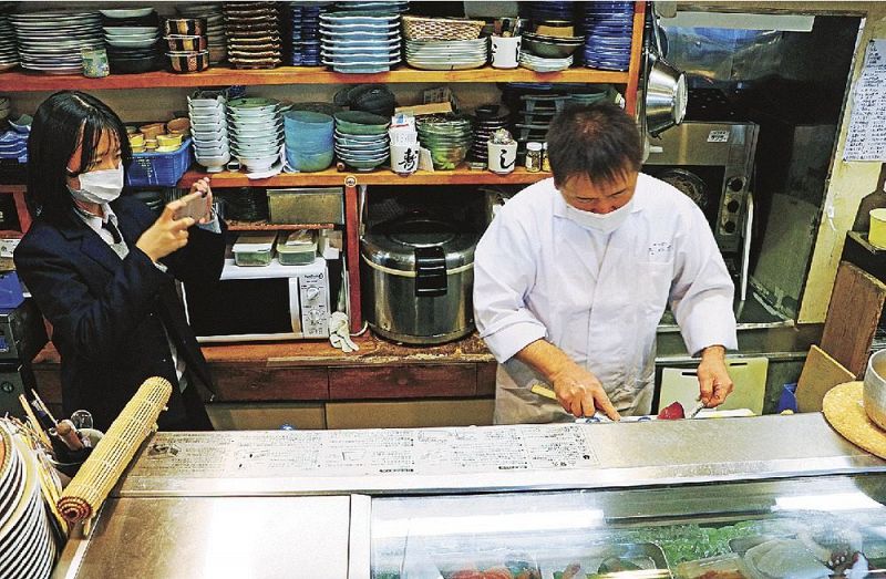 調理風景を撮影する神島高校の生徒（左）＝和歌山県田辺市新庄町で