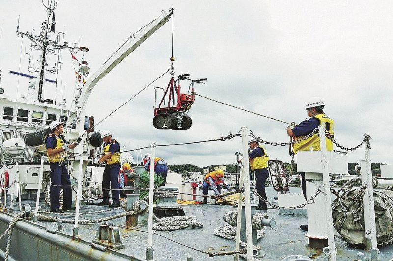 復旧作業に必要な機材を巡視艇に積み込む乗組員ら（８日、和歌山県串本町串本で）