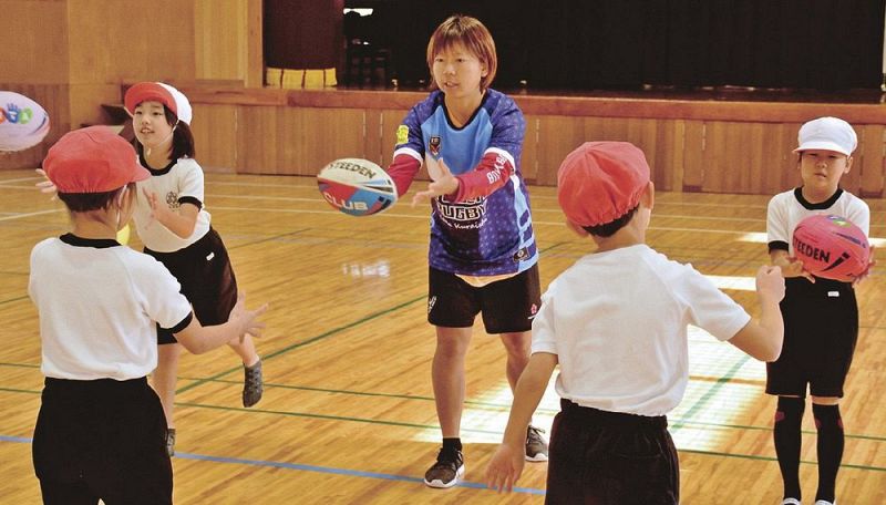 タッチラグビーを児童に教える倉石佳奈さん（１４日、白浜町の白浜第一小学校で）