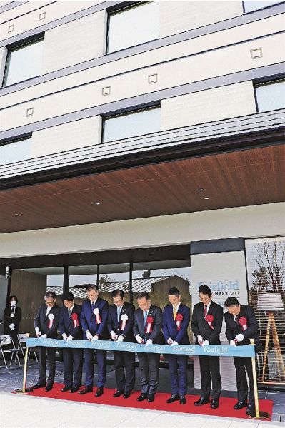 リボンカットでホテルの開業を祝う関係者（和歌山県串本町くじの川で）