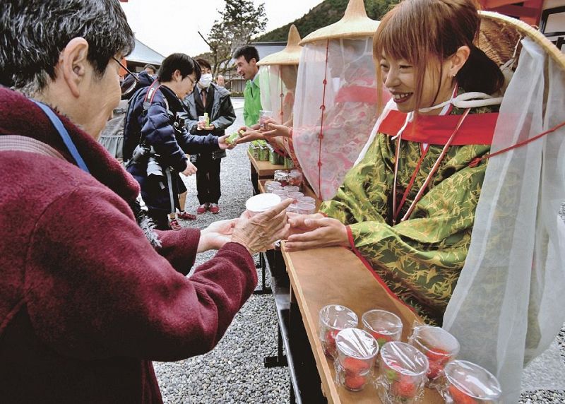 参拝者らにイチゴを配る関係者（１６日、和歌山県那智勝浦町で）