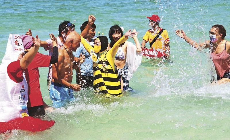 白良浜で初泳ぎを楽しむ海水浴客ら（３日、和歌山県白浜町で）