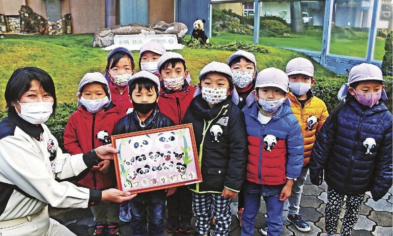 パンダ「永明」の前で、中尾建子副園長（左）に手作りのメッセージプレートを贈った園児たち＝１７日、和歌山県白浜町のアドベンチャーワールドで