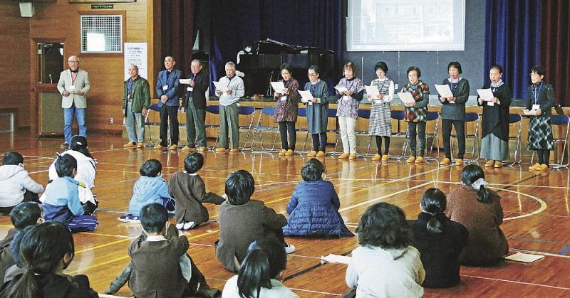 児童たちの前で旧校歌を披露する卒業生。楽譜を作った上西浩子さんがピアノを演奏した（和歌山県白浜町の白浜第二小学校で）