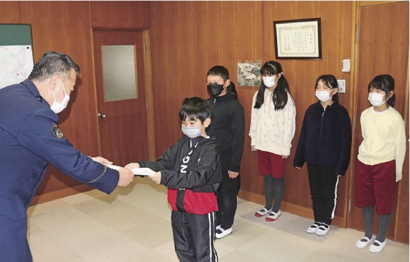 泉政勝署長（左）から感謝状を受け取る児童＝２２日、和歌山県串本町出雲で