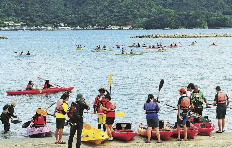 シーカヤックを体験する生徒でにぎわう橋杭海水浴場（和歌山県串本町くじの川で）