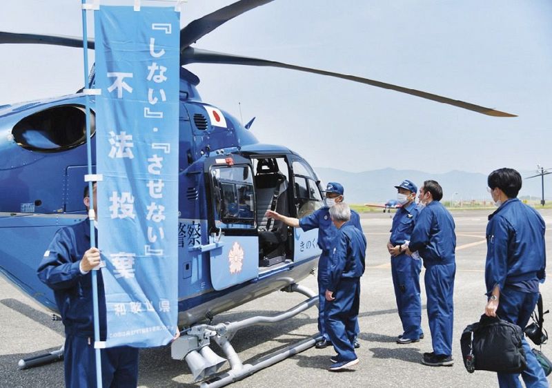 県警航空隊のヘリに乗り込む、県廃棄物指導室の職員ら（白浜町で）