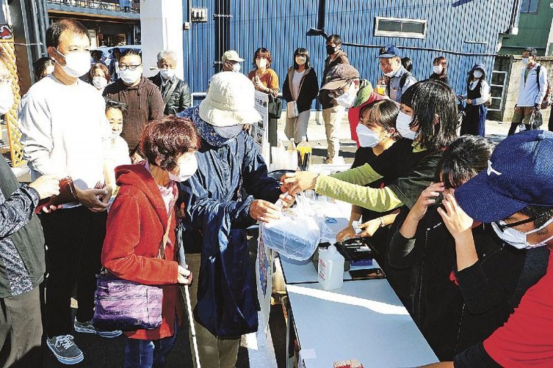 長い行列ができた東陽中学校の「ＴＯＹＯマート」。販売を手伝う神島高校１年生（１２日、和歌山県田辺市湊で）