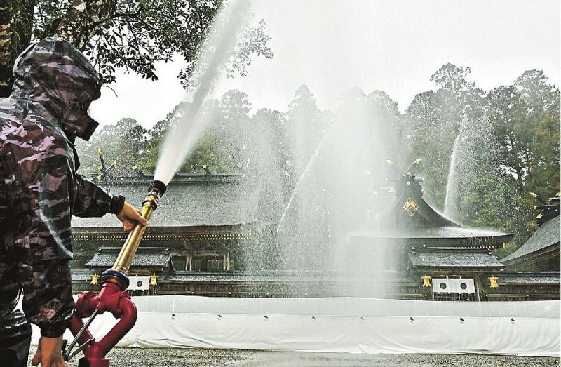 備え付けの放水銃を使い、本殿に水をかける訓練の参加者（２２日、和歌山県田辺市本宮町で）