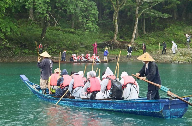 雨の中、日置川を川舟で渡る大阪国際中学校の生徒（１４日、和歌山県白浜町安居で）
