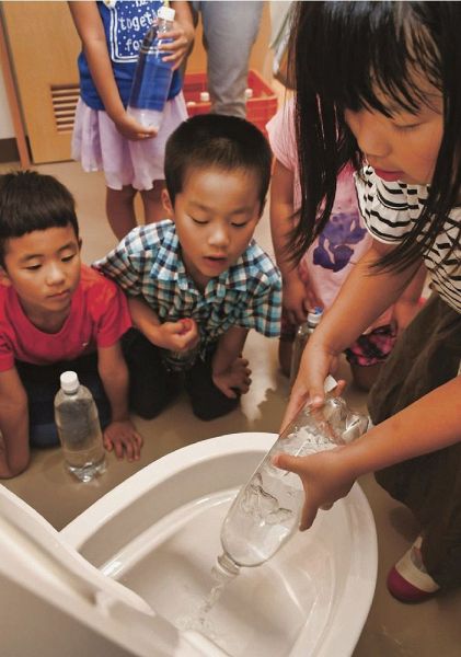 昨年７月にあった防災授業で、災害配慮トイレの使い方を学ぶ児童（和歌山県田辺市芳養町で）