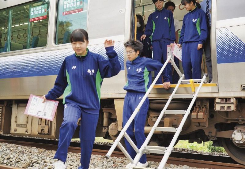 巨大地震が発生し、緊急停車したと想定した列車から避難する中学生（２５日、和歌山県みなべ町芝で）