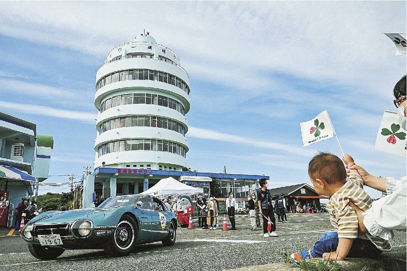 沿道からの応援を受けながら潮岬観光タワー前を出発するクラシックカー（和歌山県串本町潮岬で）