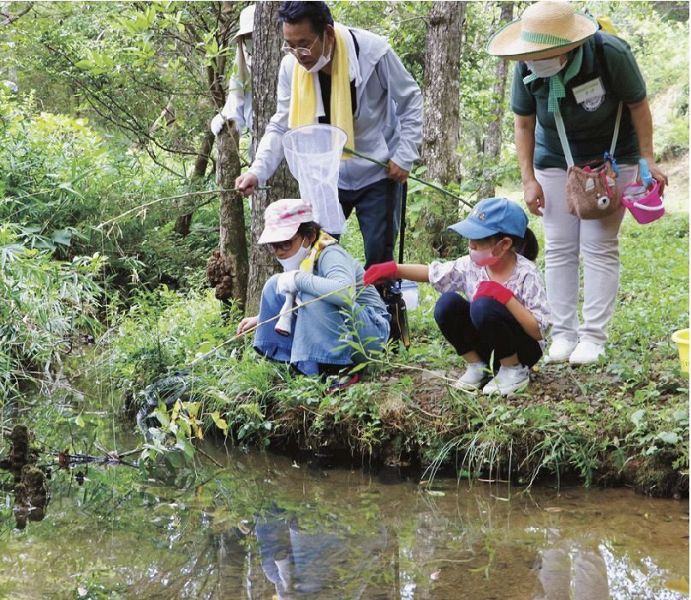 さおを構え、ザリガニ釣りに夢中の小学生（２日、和歌山県田辺市稲成町で）