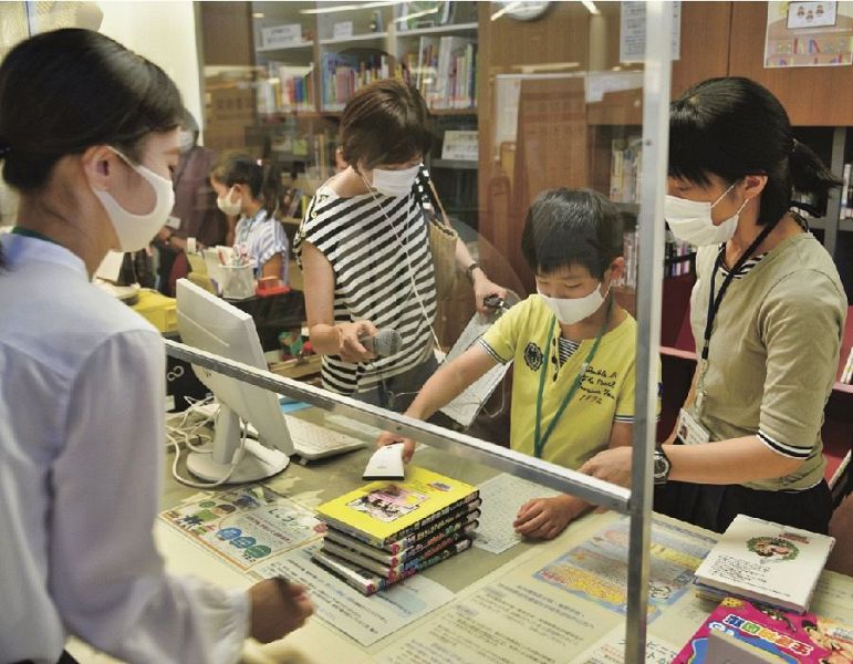 職員に教わりながら、カウンター業務を体験する児童（和歌山県田辺市新庄町で）