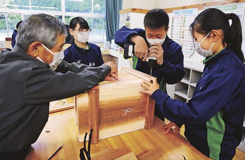 下村勤さん（左）に教わってニホンミツバチの巣箱を作る生徒＝２６日、和歌山県みなべ町滝で