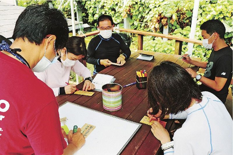 短冊に願い事を書き込むダイバー（和歌山県串本町串本で）