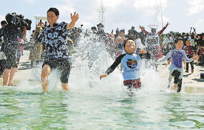 テープカットの合図で海へ駆け込む海水浴客（３日、和歌山県白浜町で）