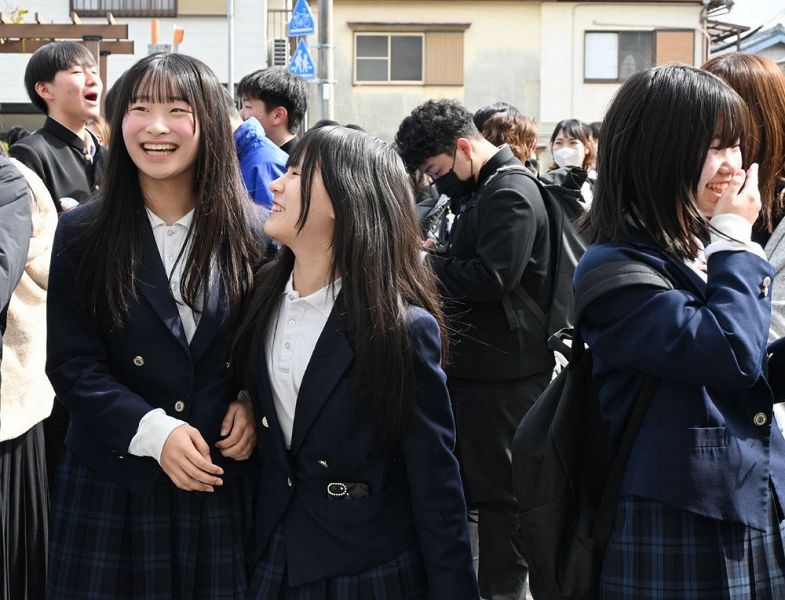 番号を見つけ、笑顔で友人と喜ぶ受験生（１８日、和歌山県田辺市文里２丁目で）
