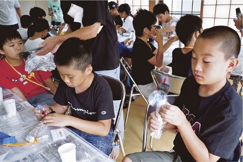 備長炭電池を使ったモーターでプロペラを回す子どもたち（和歌山県みなべ町清川で）