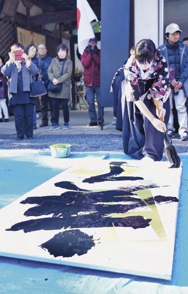 力強い筆運びで大書き初めを披露する南部高校書道部の生徒（和歌山県みなべ町埴田で）