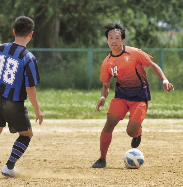 攻め込む南紀オレンジサンライズＦＣの阪本匠馬選手（和歌山市福島で）