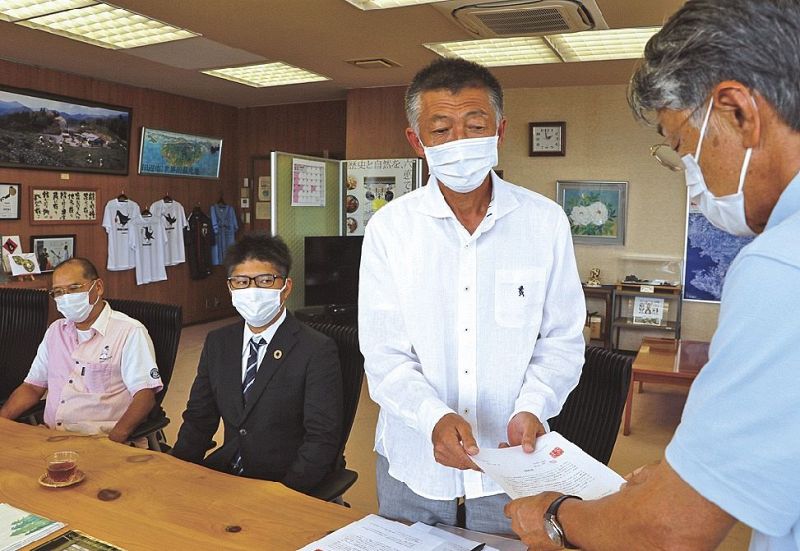 真砂充敏市長（手前）に嘆願書を手渡す田辺飲食業組合の松浦哲浩組合長＝２日、和歌山県の田辺市長室で