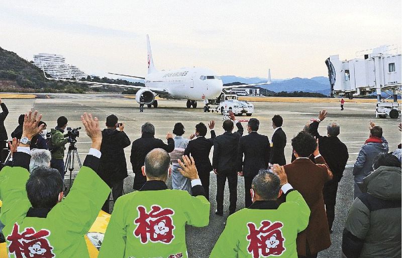 南紀白浜空港から出航する臨時便を手を振って見送る関係者（２日、和歌山県白浜町で）