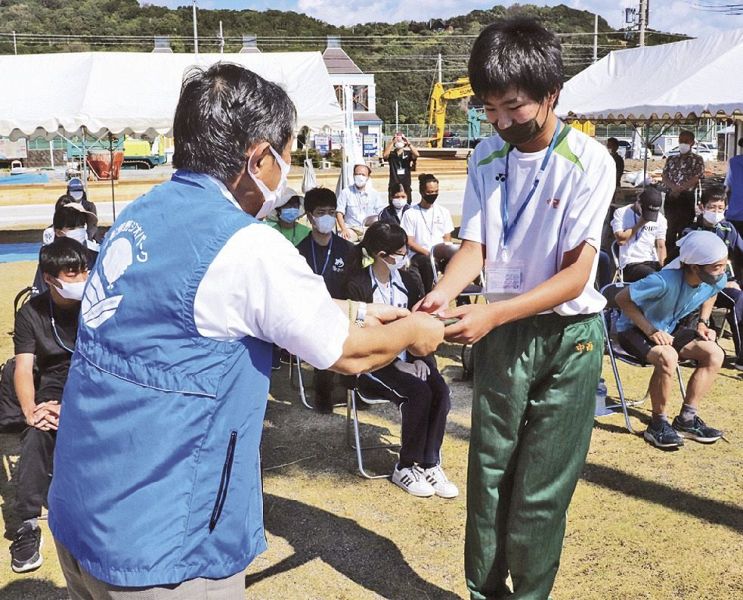 仁坂吉伸知事（左）から団員証と探偵団手帳を受け取る団員＝和歌山県白浜町日置で