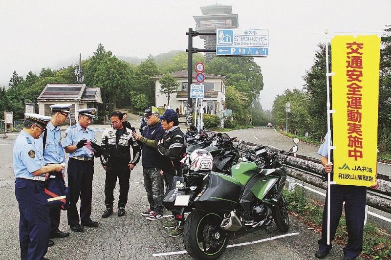 道の駅ごまさんスカイタワー駐車場で、ライダーに安全運転を呼びかける田辺署員ら（田辺市龍神村龍神で）
