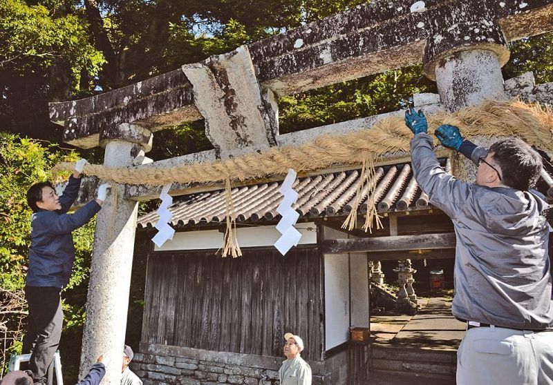 鳥居のしめ縄を掛け替える神社総代（和歌山県上富田町生馬で）