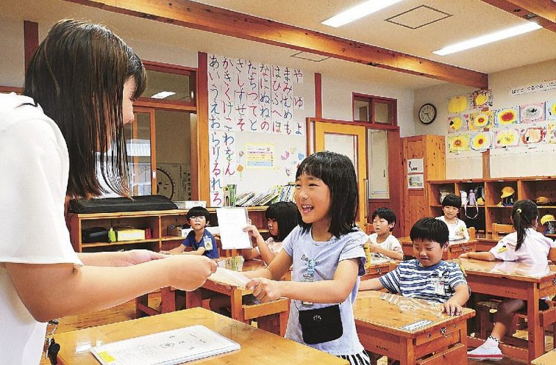 初めての通知簿を受け取る新庄小学校の１年生（１８日、和歌山県田辺市新庄町で）