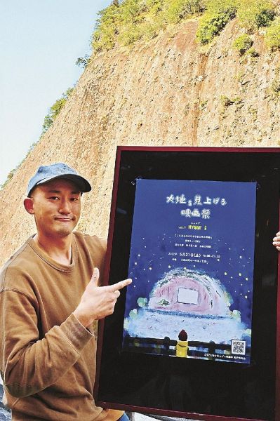 ポスターを手に映画祭をアピールする実行委員長の田堀穣也さん（和歌山県古座川町相瀬で）