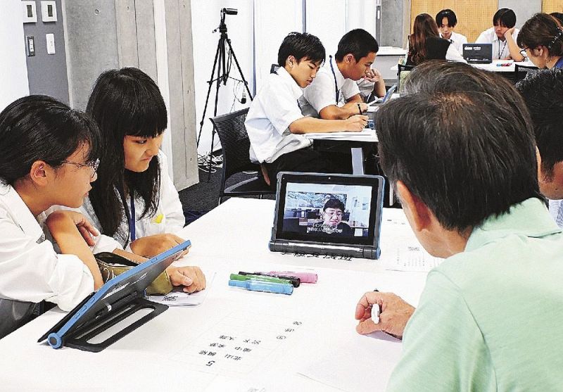 震災体験者のインタビュー動画を見ながら、災害発生後の課題について考える中学生と地域の大人（１９日、和歌山県田辺市東山１丁目で）